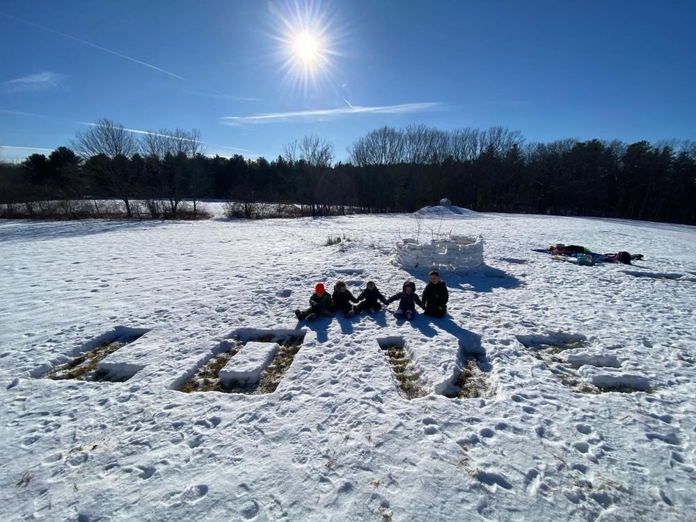 Children sitting together in a snowy field