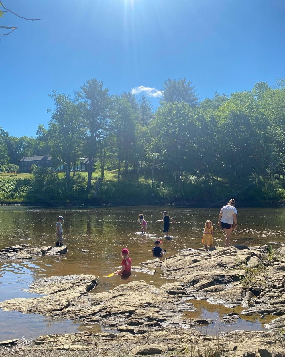 Summer campers wading in a sunny river