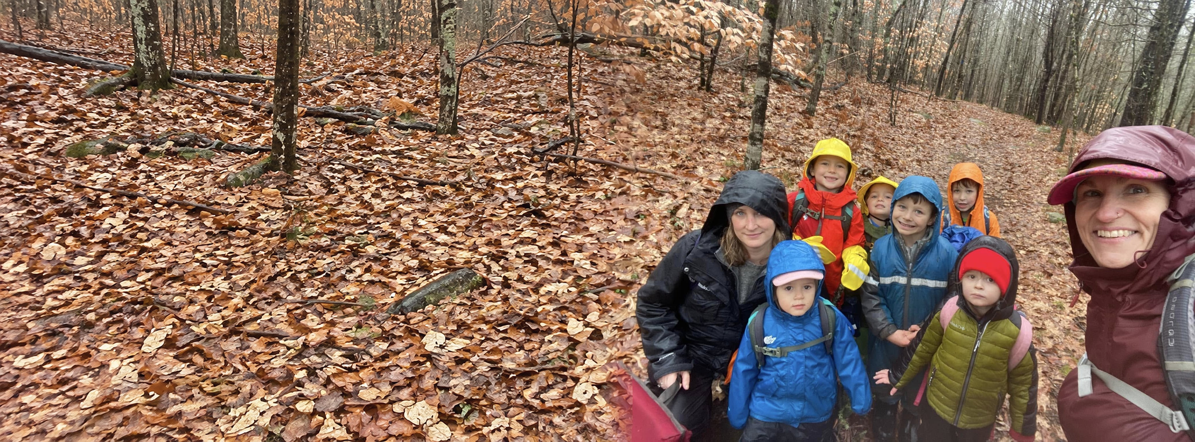 Dawn and a group of kids in bright rain gear on a leaf-covered trail